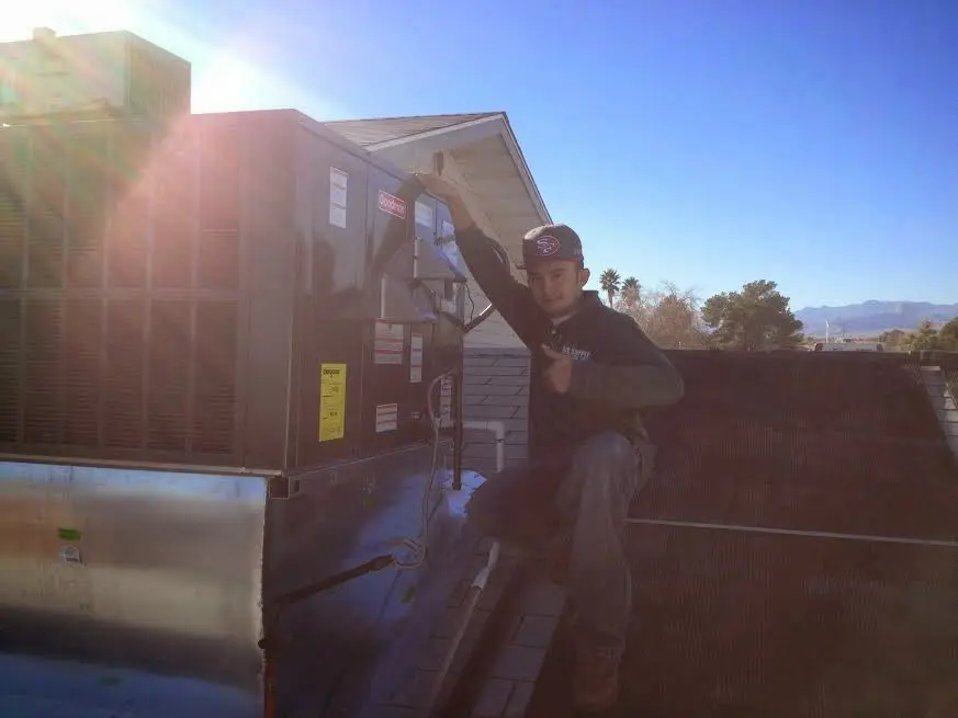 HVAC technician performing HVAC Inspection on a rooftop unit in Dalton